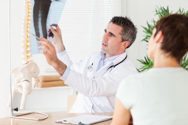 le médecin montre les dommages à la colonne vertébrale dus à l'ostéochondrose cervicale